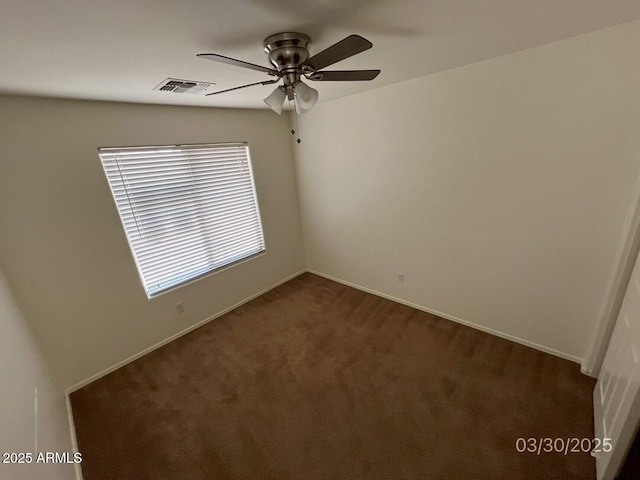 empty room with a ceiling fan, baseboards, dark carpet, and visible vents