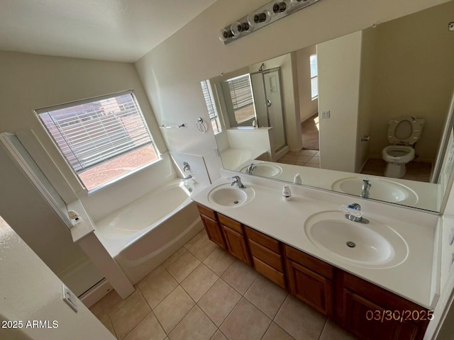 bathroom featuring tile patterned floors, a bath, and a sink