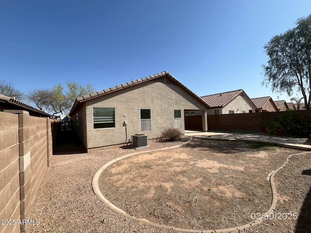 back of property featuring a patio area, stucco siding, an attached garage, a fenced backyard, and a tiled roof