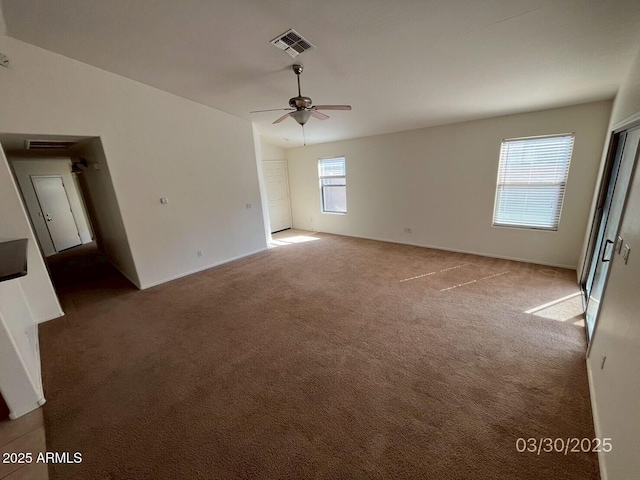 carpeted empty room featuring visible vents and ceiling fan