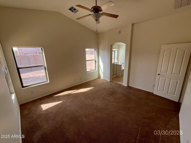 unfurnished bedroom featuring arched walkways, high vaulted ceiling, visible vents, and carpet