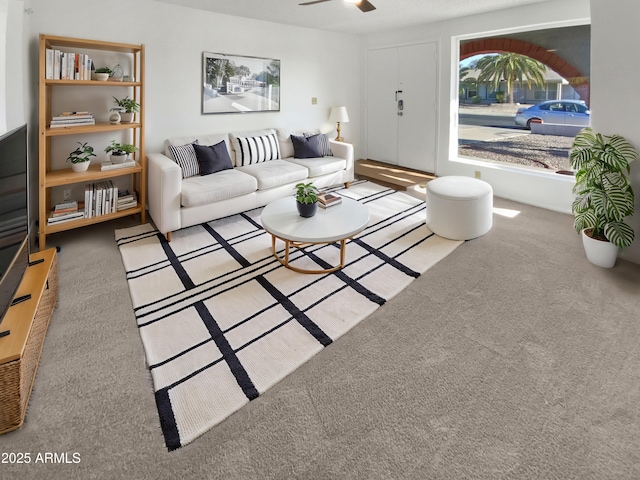 carpeted living room featuring ceiling fan