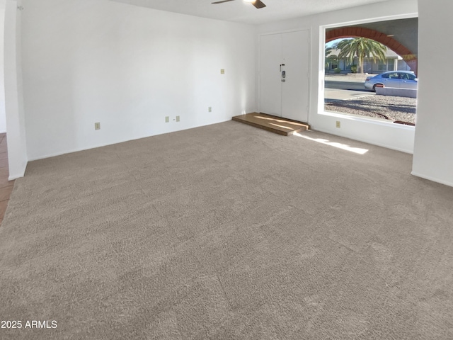 unfurnished living room with carpet floors and ceiling fan