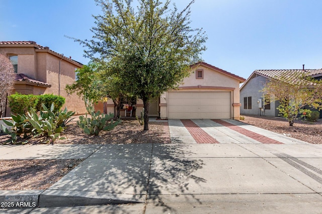 mediterranean / spanish-style house with stucco siding, a tiled roof, concrete driveway, and a garage