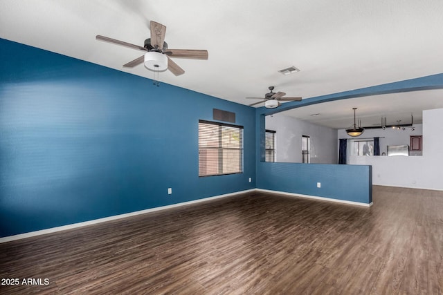 unfurnished living room featuring wood finished floors, a ceiling fan, baseboards, and visible vents