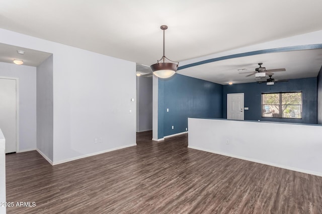 unfurnished living room featuring dark wood finished floors, ceiling fan, and baseboards