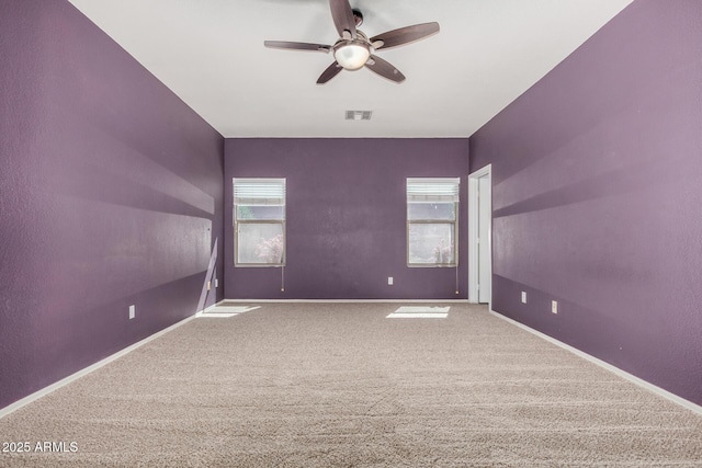 spare room featuring visible vents, baseboards, ceiling fan, and carpet flooring