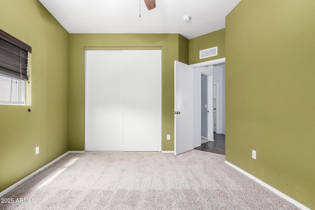 unfurnished bedroom featuring a ceiling fan, baseboards, visible vents, a closet, and carpet flooring