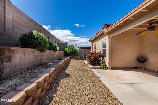 view of yard with a fenced backyard, a patio, and ceiling fan