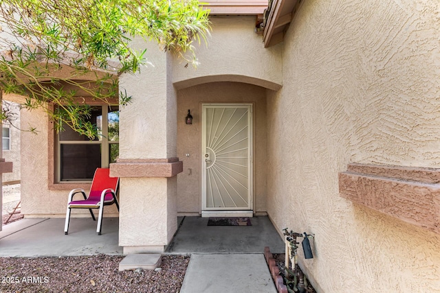 doorway to property featuring stucco siding