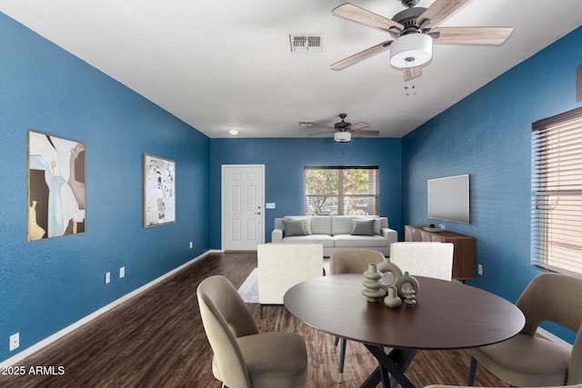 dining area with baseboards, wood finished floors, visible vents, and ceiling fan