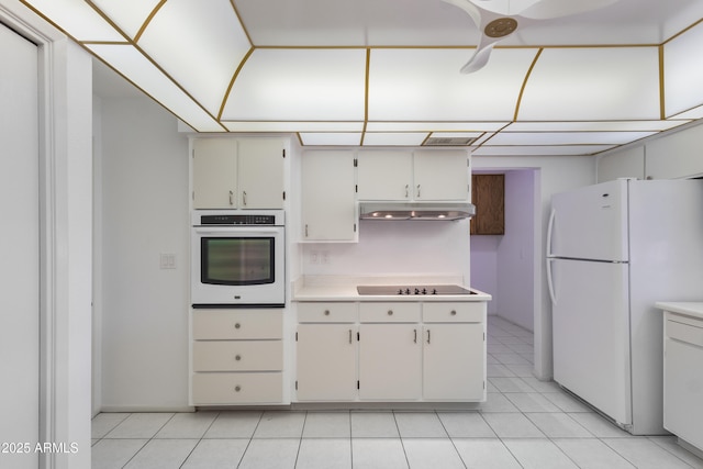 kitchen featuring white appliances, light countertops, under cabinet range hood, and light tile patterned floors