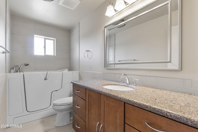 full bath featuring a garden tub, vanity, and toilet