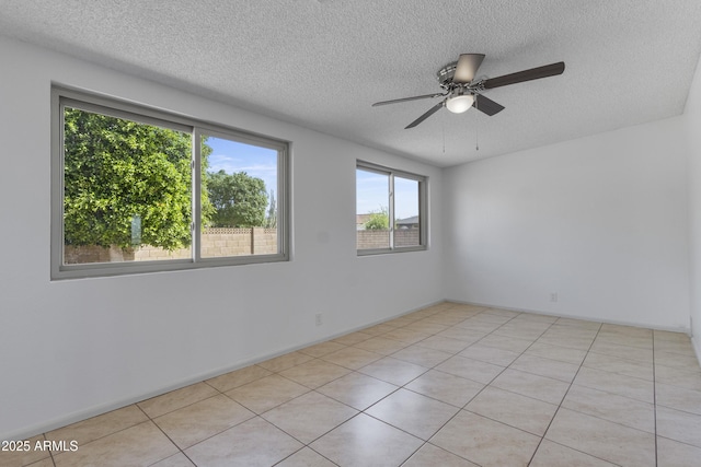 unfurnished room with a textured ceiling, light tile patterned flooring, and a ceiling fan