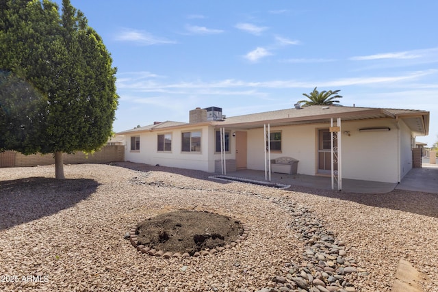 rear view of property with a patio area, a chimney, and fence