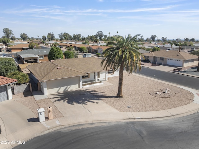 view of front of home with a garage, a residential view, and driveway