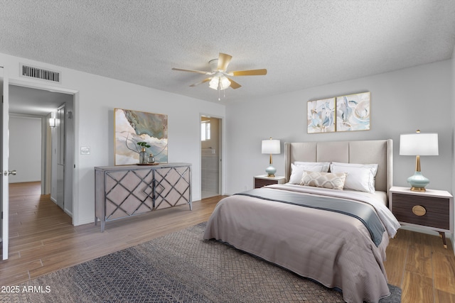 bedroom featuring a textured ceiling, wood finished floors, and visible vents