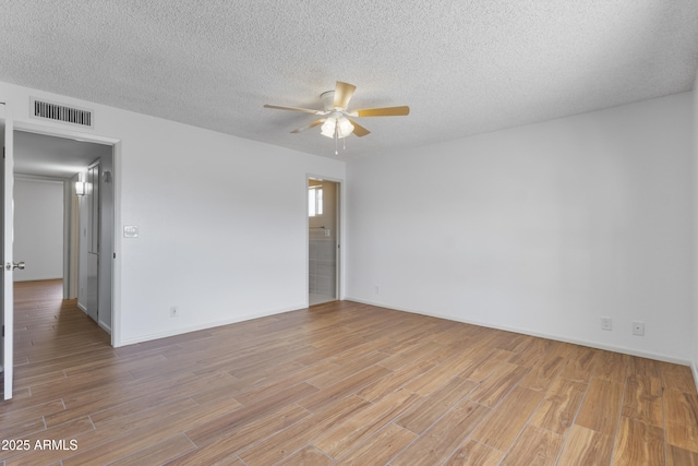 unfurnished room featuring baseboards, visible vents, a ceiling fan, light wood-style flooring, and a textured ceiling