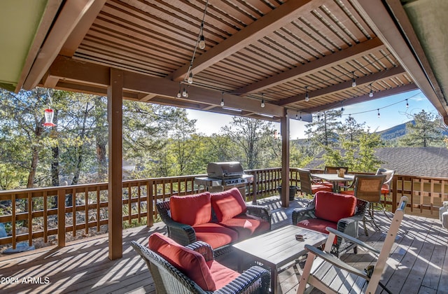 wooden terrace with a grill and an outdoor hangout area