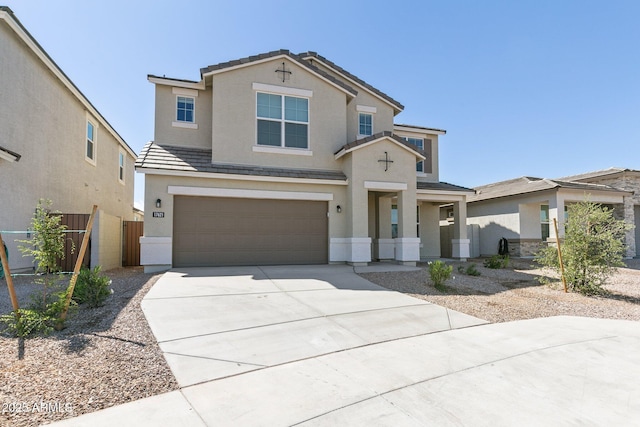 view of front of property with a garage, a tile roof, concrete driveway, and stucco siding