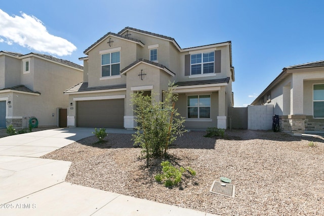 traditional home with a garage, a tile roof, concrete driveway, and stucco siding