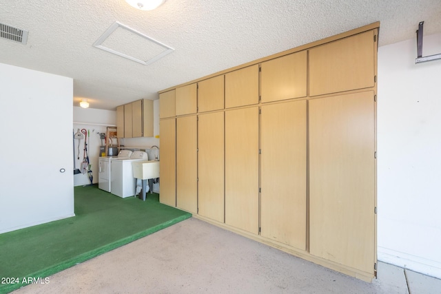 interior space with sink, washer and dryer, and a textured ceiling