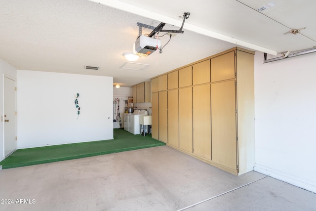 garage with a garage door opener and washing machine and clothes dryer