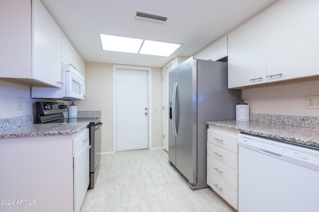 kitchen featuring light stone countertops, white cabinetry, and appliances with stainless steel finishes