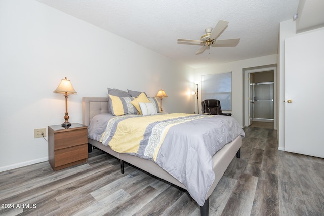 bedroom with ceiling fan, dark wood-type flooring, and a textured ceiling