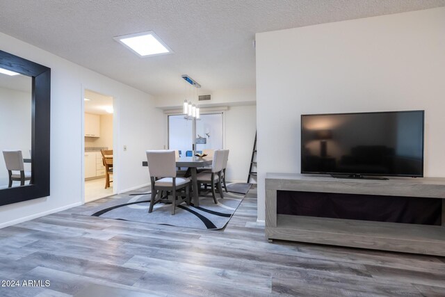 dining area with hardwood / wood-style floors and a textured ceiling