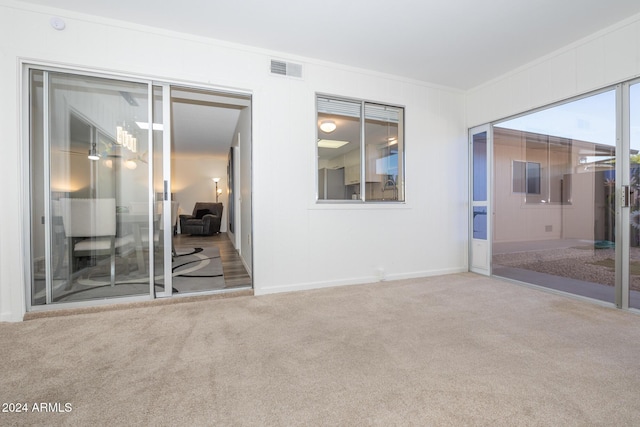 empty room featuring carpet flooring and ornamental molding