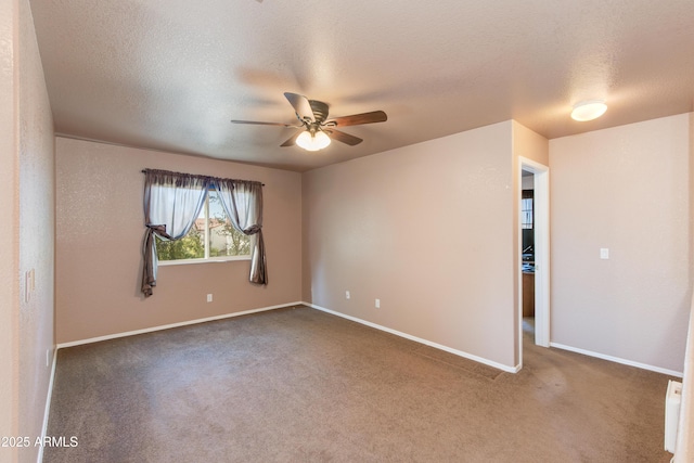 carpeted spare room featuring ceiling fan and a textured ceiling