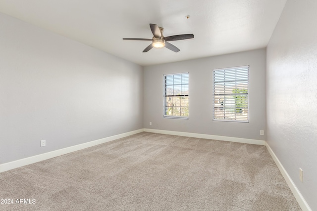 carpeted spare room featuring ceiling fan