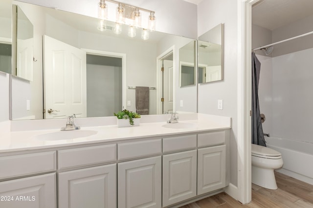 full bathroom featuring shower / bath combo, hardwood / wood-style floors, vanity, and toilet