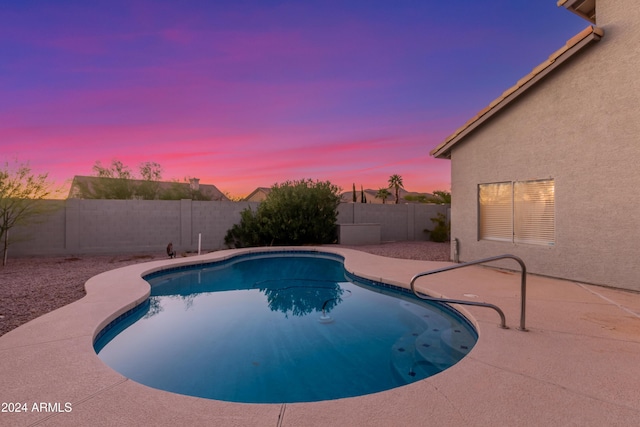 pool at dusk with a patio