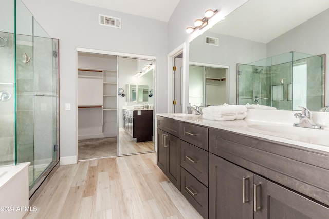 bathroom with vanity, wood-type flooring, and a shower with door