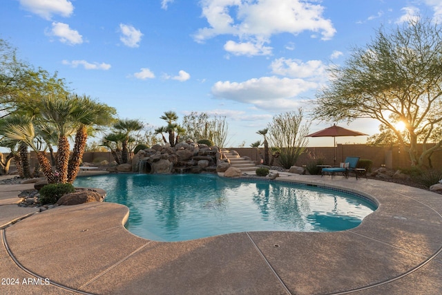 view of swimming pool with pool water feature and a patio area