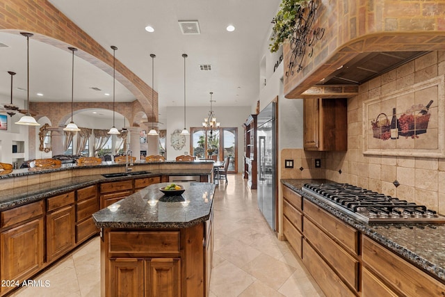 kitchen featuring decorative light fixtures, sink, tasteful backsplash, and a chandelier