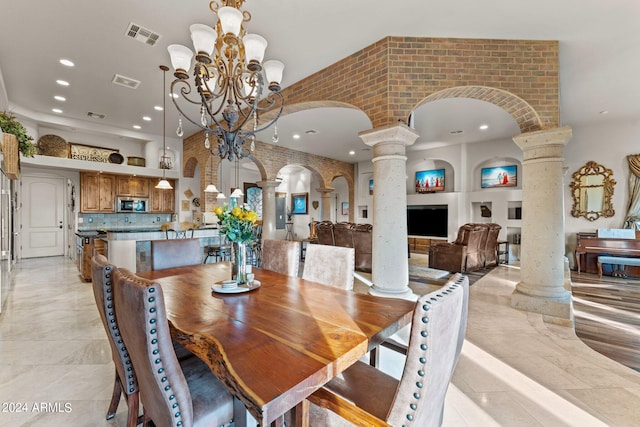 dining space with a notable chandelier, decorative columns, and light tile floors