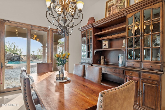 tiled dining room featuring an inviting chandelier