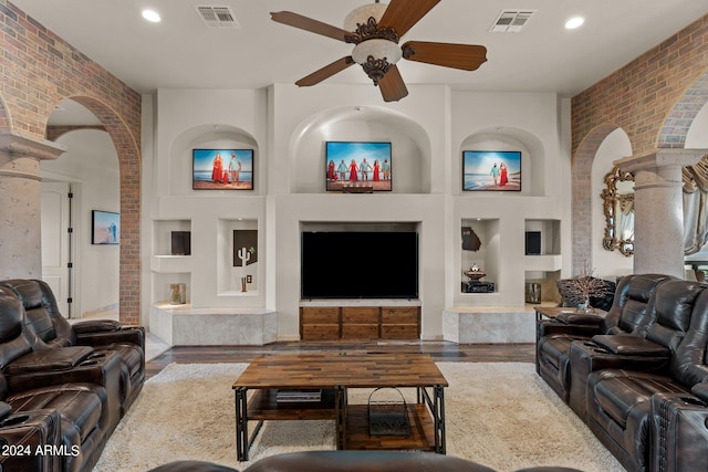 living room with wood-type flooring, brick wall, and built in shelves