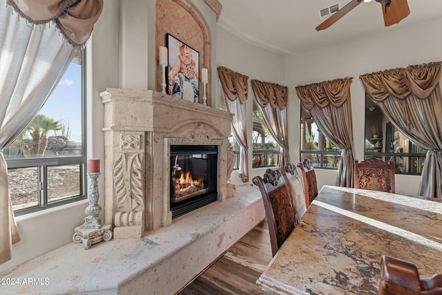 interior space featuring ceiling fan, hardwood / wood-style flooring, and a high end fireplace