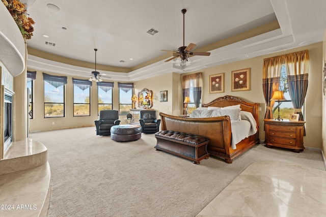 bedroom featuring tile floors, ceiling fan, and a tray ceiling