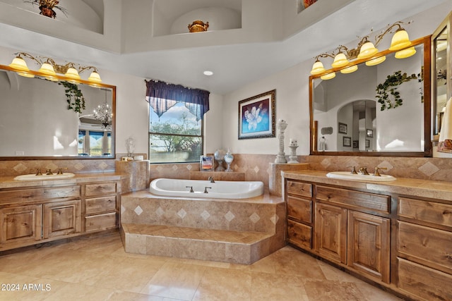 bathroom with a relaxing tiled bath, dual bowl vanity, tile floors, and a towering ceiling