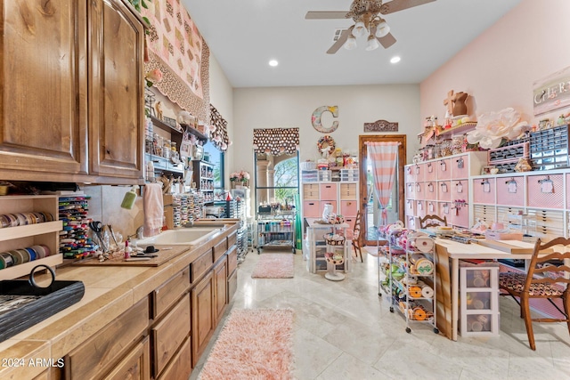 kitchen featuring tile countertops, ceiling fan, and light tile floors