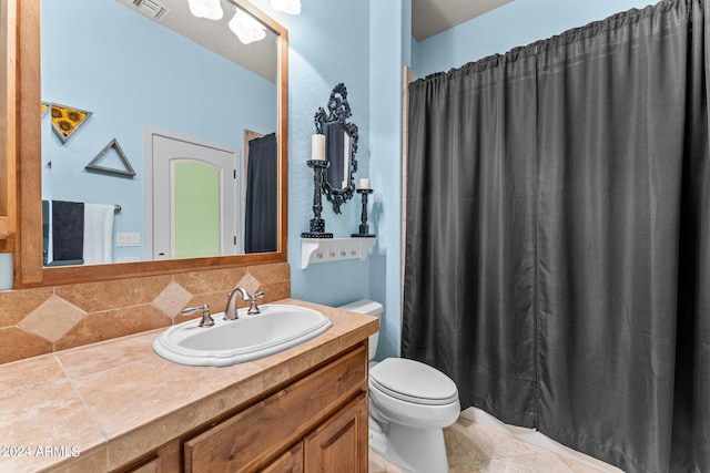 bathroom featuring backsplash, vanity, tile floors, and toilet