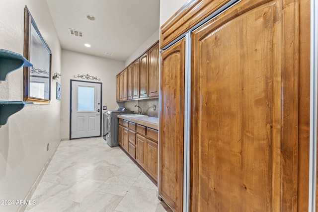 kitchen with sink, light tile flooring, and separate washer and dryer