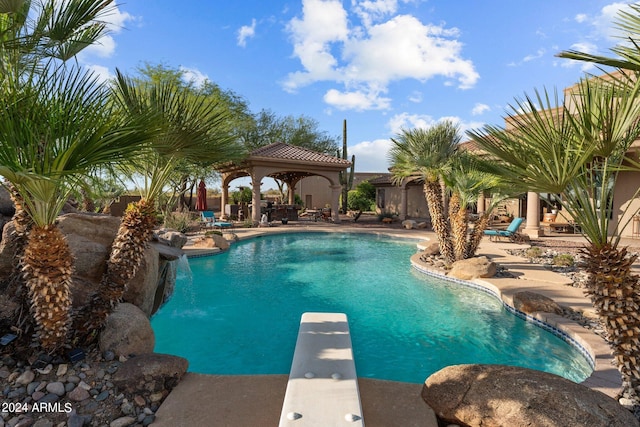 view of swimming pool with a patio area, a gazebo, and a diving board