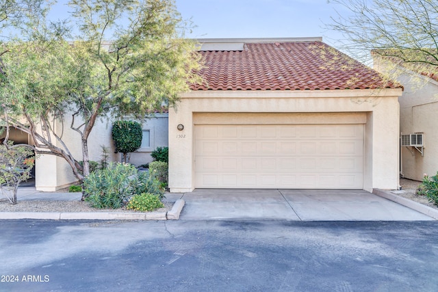 mediterranean / spanish-style house with a wall mounted AC and a garage