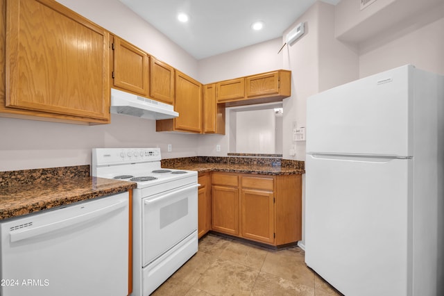 kitchen with dark stone counters and white appliances